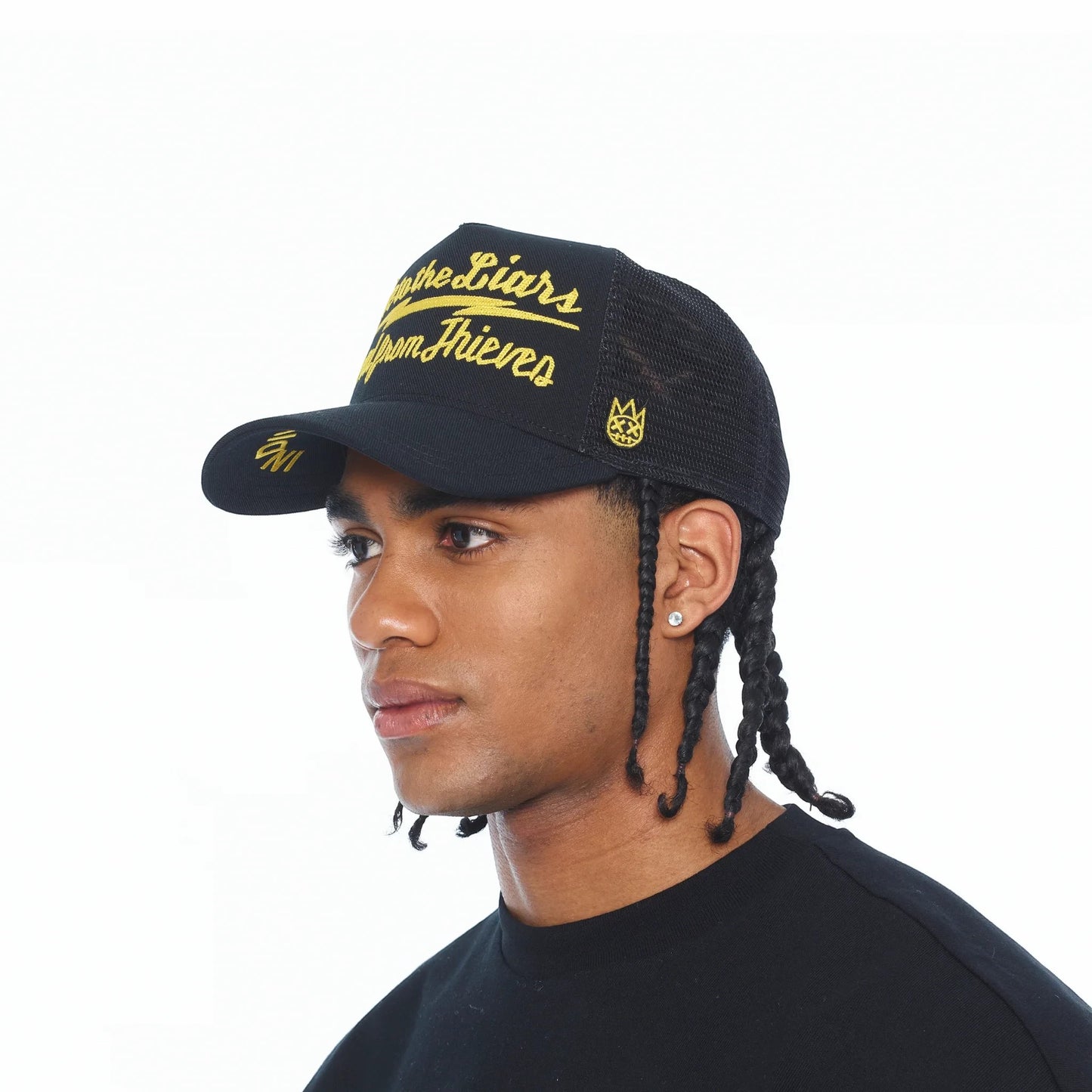 Ballers Clothing Shop black mesh back trucker hat with yellow Lie to the Liars embroidery worn by a male model