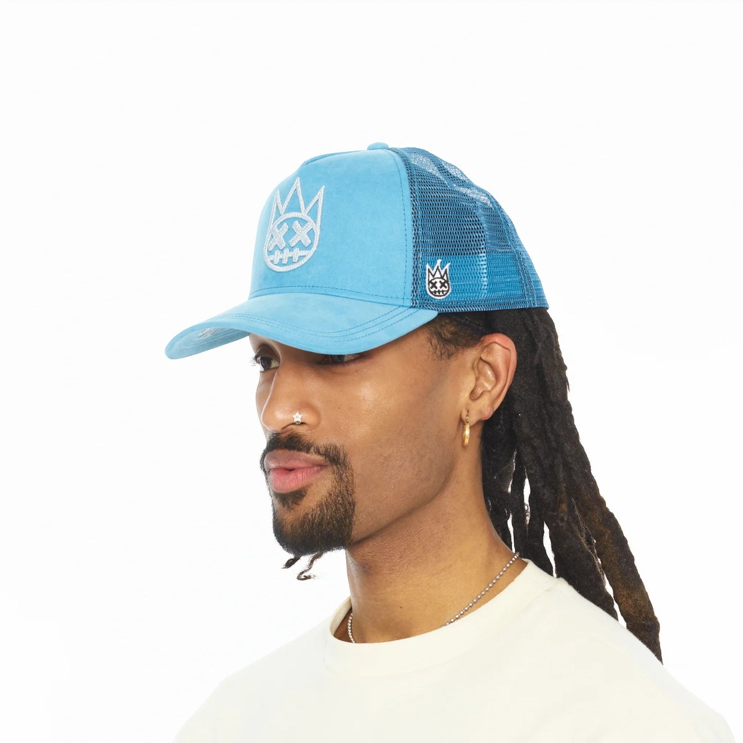 Ballers Clothing Shop Navagio Bay blue suede trucker hat with mesh back and raised chain-stitch logo on a model