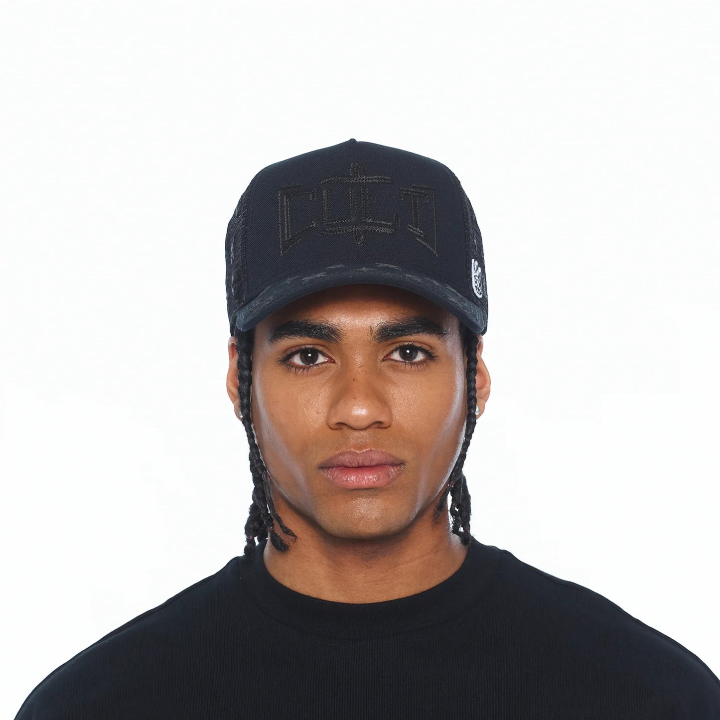 A man wearing a black Ballers Clothing Shop mesh back trucker hat with a rope detail and embroidered front logo.