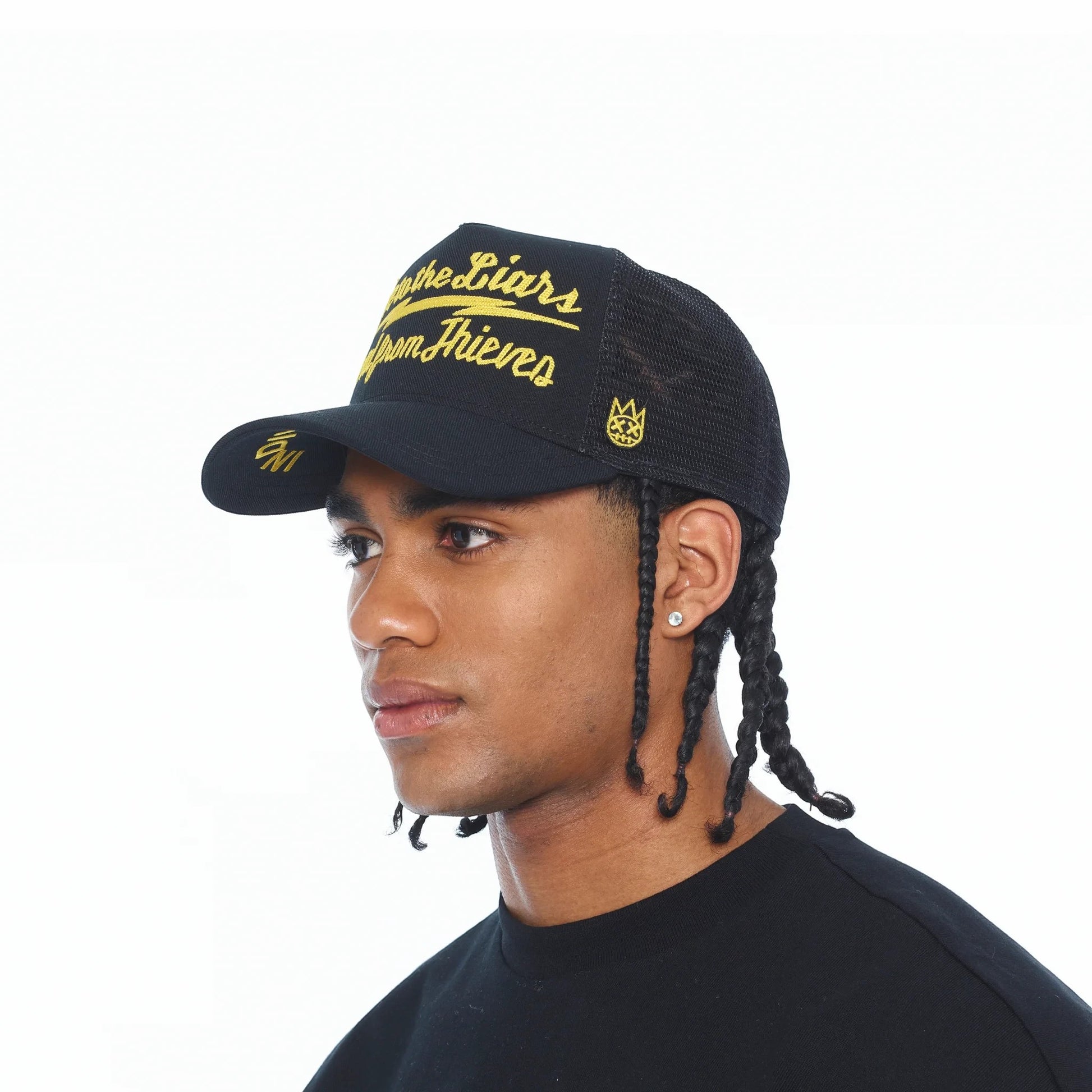 Ballers Clothing Shop black mesh back trucker hat with yellow Lie to the Liars embroidery worn by a male model