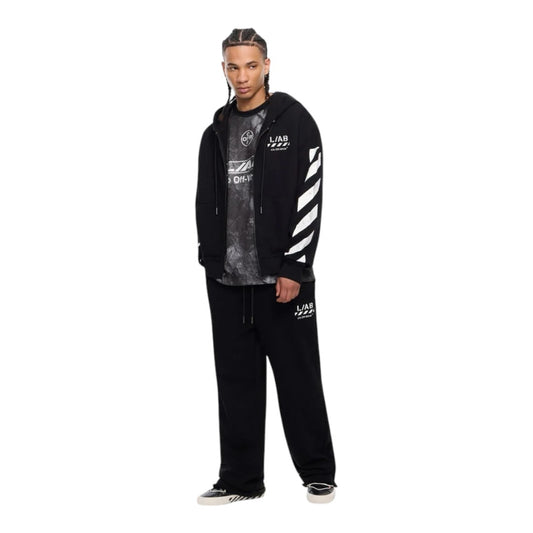 Model wearing Ballers Clothing Shop L/AB c/o Off-White black cotton zip hoodie with white diagonal sleeve motifs.