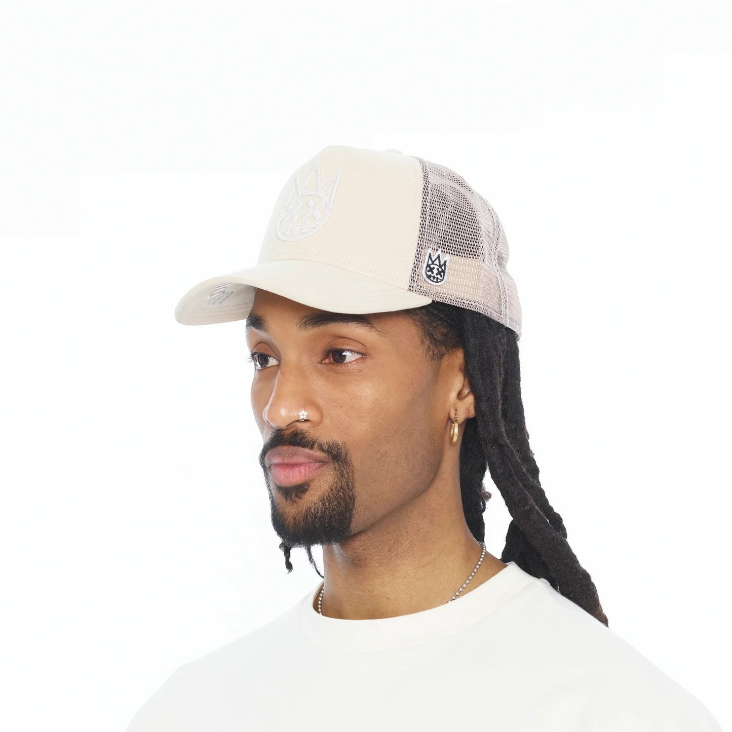 Ballers Clothing Shop cream suede trucker hat with mesh back and raised chain-stitch logo worn by a man.