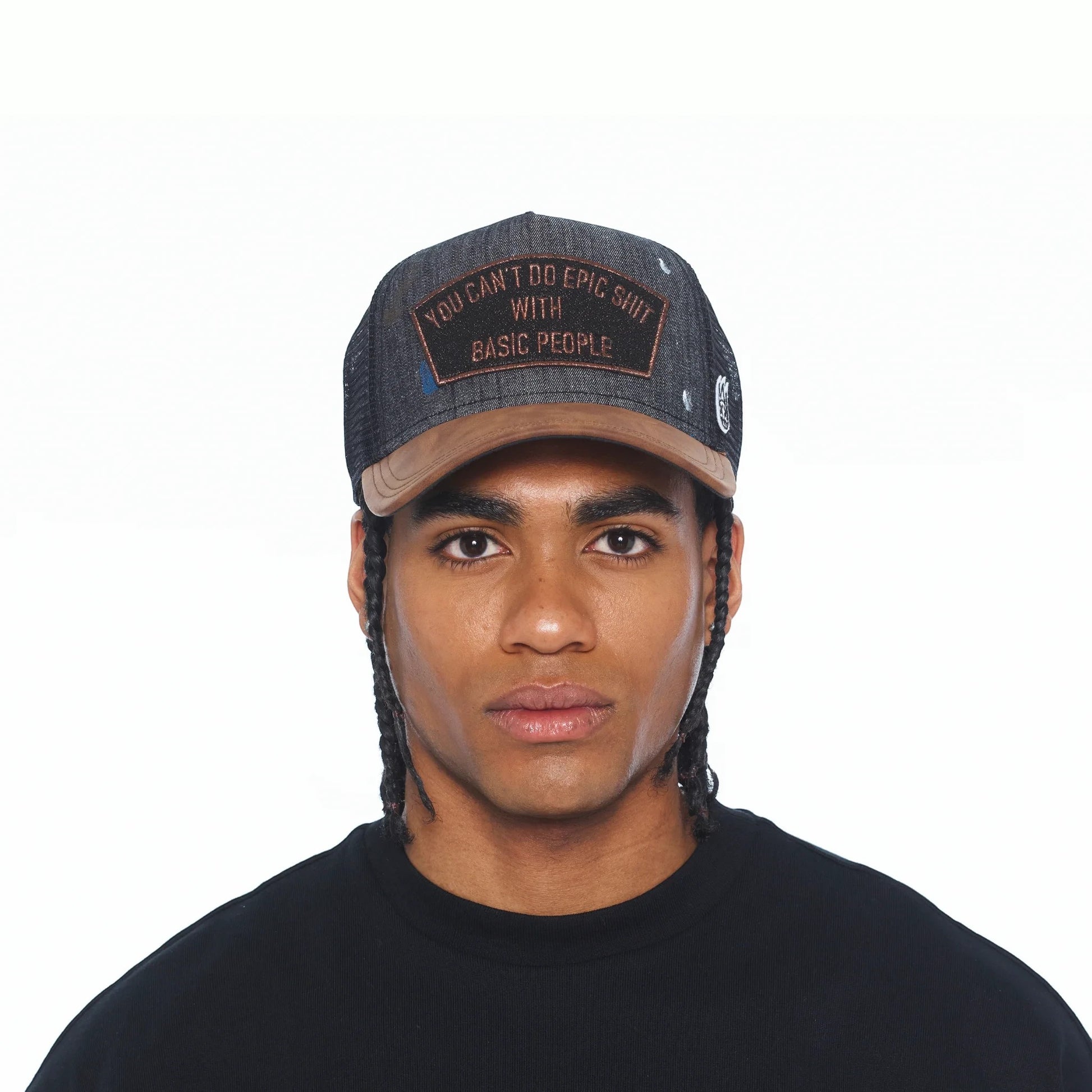 Ballers Clothing Shop black distressed denim trucker hat with paint splatter and embroidered patch on a male model